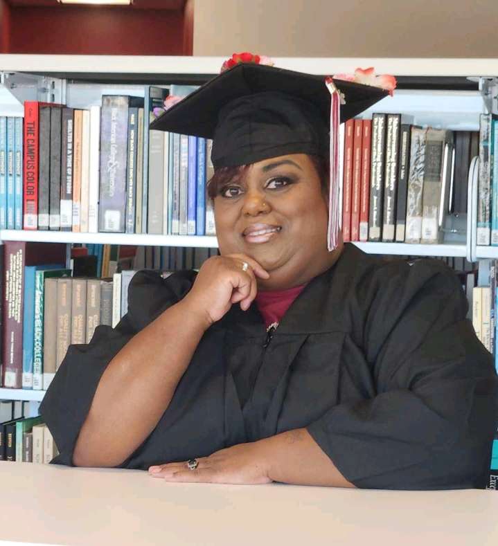 student smiling in graduation gown